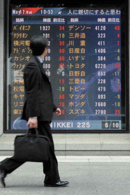 Man in suit looking at stock tickers.